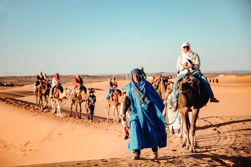 Tours por Marruecos – viajeros con camellos en el Sahara