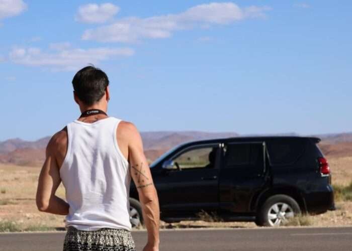 Image is for a tourist during our Moroccan holiday tour from Marrakech to Fes. The picture show the back of the man with a Toyota Prado in the background