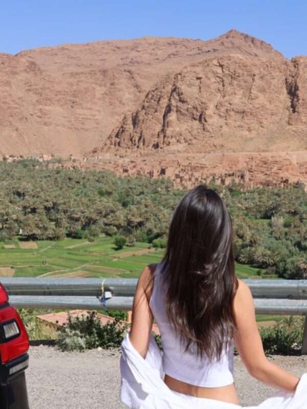 The image is for a tourist in Todra Gorge with SUV in the background